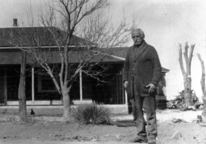 Bonita Postmaster Miles L. Wood standing outside his home
