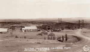 Long shot of few buildings (western and Navajo) and bridge; written on image: Little Colorado Trading Post, Cameron, Arizona