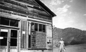 Courtland post office with huge bank of post office boxes; woman standing beside building
