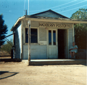 Hackberry post office in a small shack with postmaster sitting outside on the porch